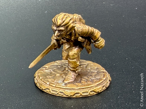 Closeup of a miniature of a goblin with a sword